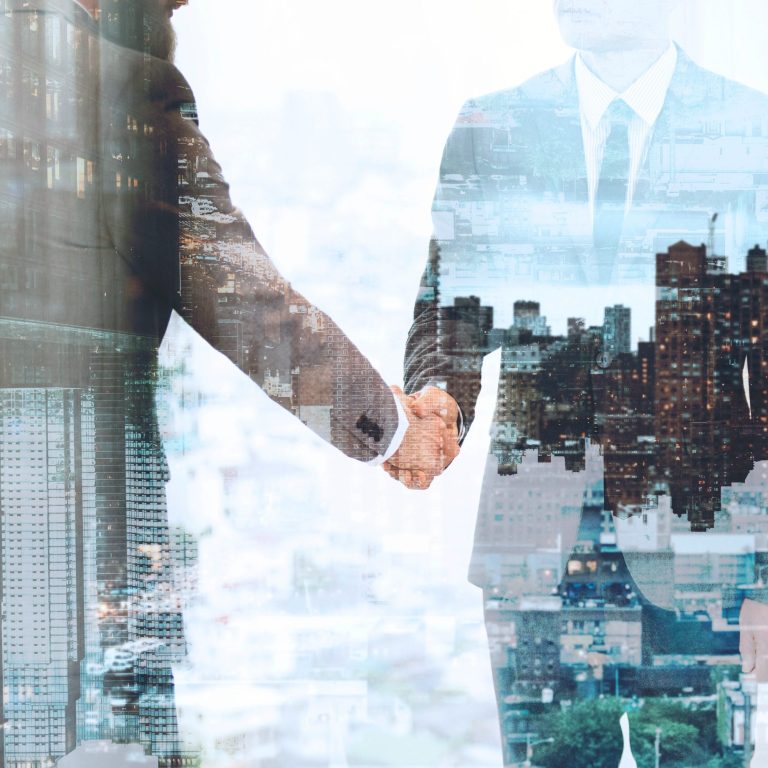 Dos personas de negocios se dan la mano con un fondo de ciudad.